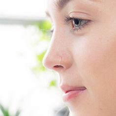 "Solid 9ct WHITE Gold nose ring, hoop with ball for secure and discrete placement. This white gold nose ring has been handmade in my studio in Belfast.  This white gold nosering is made from 0.5mm/26Gauge half hard wire and are the thinnest on Etsy. The ring measures 8mm in diameter and is a comfortable fit for most nose piercings, if you are unsure this will fit you please measure from your piercing to the  bottom of the nostril. To finish them, the rings have been gently hammered smooth, burnished & polished for durability.  Simply bend sideways slightly to thread through your ear, nose or other piercing, then bend back into shape to wear. Other sizes are also available and can be made to order. If you require a different size please leave a note at the checkout. I strongly believe in et Septum Ring Piercing, Ring Piercing, Nose Piercings, White Gold Hoops, Gold Nose Rings, Nose Jewelry, Ethical Jewelry, Traditional Jewelry, Sterling Silver Hoops