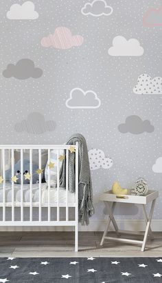 a baby's room with clouds and stars on the wall