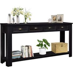 a black console table with three drawers and two vases on the bottom shelf next to books