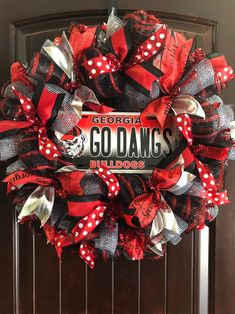 a red and black wreath with the words go dawgs on it is hanging on a door