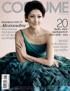 a woman in a blue dress sitting on top of a magazine cover with her arms crossed