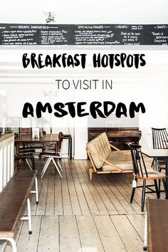 a restaurant with wooden tables and chairs in front of a chalkboard sign that says breakfast hotspots to visit in amsterdam