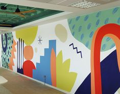 a large mural on the side of a wall in an office building with green ceilings