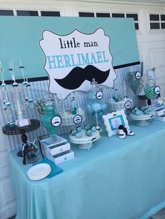 a blue table topped with lots of desserts and candy bar signs on top of it