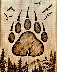 a drawing of a bear paw with birds flying around it