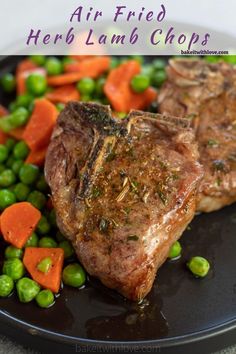 two pieces of steak on a plate with peas and carrots next to it are the words air fried herb lamb chops