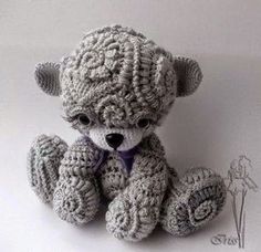 a crocheted teddy bear sitting on top of a white table