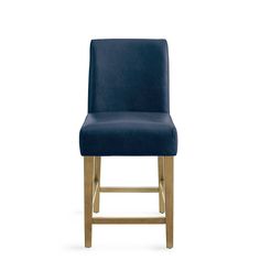 an upholstered bar stool with gold legs and a blue velvet seat pad, viewed from the front