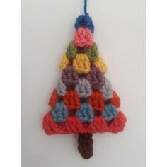 a crocheted christmas tree ornament hanging on a wall