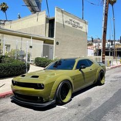 a yellow car parked in front of a building on the side of a road with palm trees