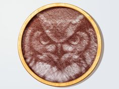 an animal's head is shown in the center of a circular wooden frame on a white background