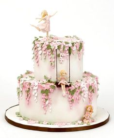 a three tiered cake decorated with figurines on top of it and vines