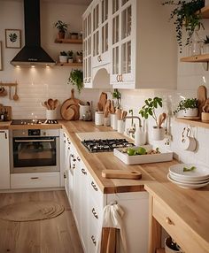 a kitchen filled with lots of wooden counter top next to a white stove top oven