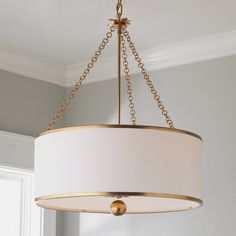 a chandelier hanging from the ceiling in a room with white walls and windows