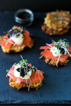 small appetizers are arranged on a black tray