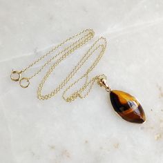 "You can choose your own gem in my store. Let me know if you would like to see options Gemstone: Brown YellowTiger Eye Gold Purity : Guaranteed 14kt pure GOLD Gem weight 9.60 carats Gem shape: Marquis Cabachon shape Gold weight: 0.56 grame Total weight: 2.48 grame The Gemstone in this pendant is ethically sourced and is exploitation free. Brown Yellow Tiger Eye is a beautiful Gemstone of patterns like no other Gemstone. Please note that the pendant is made with absolutely pure 14kt Gold. Pendant Yellow Gold Cabochon Teardrop Pendant Necklace, Marquise Birthstone Necklace For Gift, 14k Gold Gemstones With Bezel Setting For Gift, Hallmarked 14k Gold Jewelry With Teardrop Pendant, 14k Gold Hallmarked Jewelry With Teardrop Pendant, 14k Gold Hallmarked Teardrop Pendant Jewelry, Teardrop Bezel Set Necklace Gift, Teardrop Pendant Jewelry With Bezel Setting, Gift Jewelry With Bezel Setting In Teardrop Pendant Shape