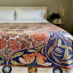 the bed is made with an intricately designed bedspread