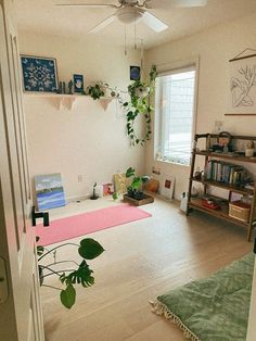 a living room filled with furniture and a pink rug on top of a hard wood floor