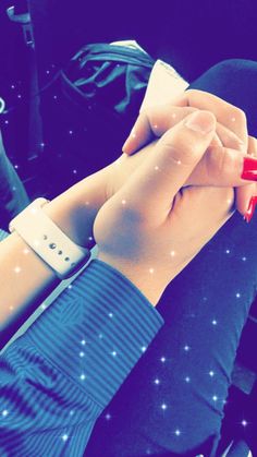 two people holding hands while sitting in a car with the lights on and stars all around them