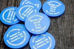 blue buttons with white words on them sitting next to each other in front of a wooden table