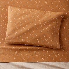 two sheets with white dots on them and one is folded over the other, in front of an orange background