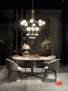 a dining room table with four chairs and a chandelier hanging from the ceiling