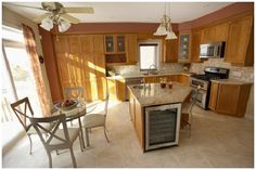 a kitchen with wooden cabinets and marble counter tops