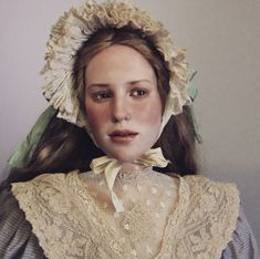 a woman with long hair wearing a bonnet and dress