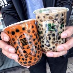 two people holding up coffee cups in their hands