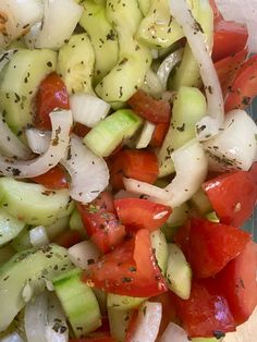 a salad with cucumbers, tomatoes and onions