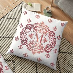 a decorative monogrammed floor pillow with the letter m in red and pink on it