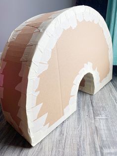 a cardboard arch sitting on top of a wooden floor