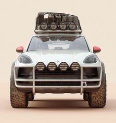 the front end of an off - road vehicle with its lights on and luggage strapped to it's roof