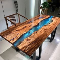 a table that is made out of wood and has blue water on the surface in it