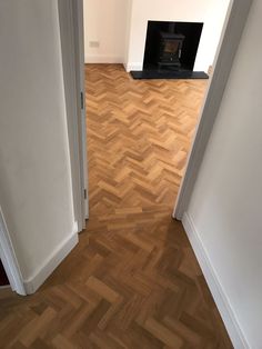 an empty room with wood floors and a fire place