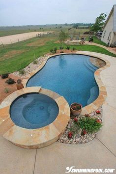 an outdoor swimming pool surrounded by landscaping