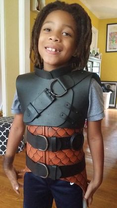 a young child wearing a costume made to look like he is holding a knife in his hand