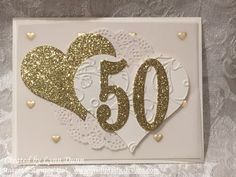 a white and gold 50th birthday card with heart cutouts on the front that says 50