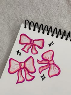 a spiral notebook with pink bows on it