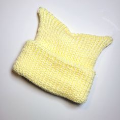 * soft, pale yellow colour  * baby beanie featuring cute little ears * gender neutral  * handmade with love  * made with soft, baby-safe yarn * machine washable and dryable * Double layered knit for extra warmth and comfort  * Brimmed baby hat that is made a tad larger so baby can get longer use of this handmade item  * Made in Ontario, Canada  * Free London Ontario pick up option available Yellow Knitted Hat One Size Fits Most, Cute Cream Knitted Hats, Yellow Hand Knitted Crochet Hat One Size, Hand Knitted Yellow Crochet Hat One Size, Cute Cream Soft Knit Hat, Yellow Hand Knitted Beanie Crochet Hat, Cute Handmade Yellow Hat, Yellow Knitted One-size-fits-most Hat, Yellow Knitted Beanie (one Size Fits Most)