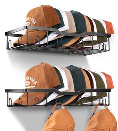 three hats are hanging on the wall and one has a hat rack in front of it