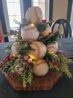 a christmas tree made out of baseballs and greenery on top of a table