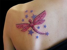 a woman's back with a pink dragon tattoo on her left shoulder and stars around it