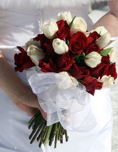 a woman holding a bouquet of red and white flowers in her hand, with the text on it