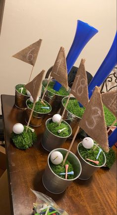 golf themed centerpieces in buckets with flags and balls on the top, sitting on a table