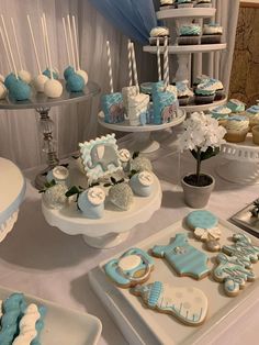 a table topped with lots of blue and white desserts