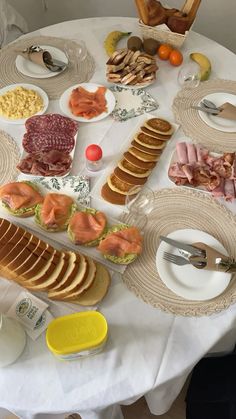 a white table topped with plates and bowls filled with different types of food on top of it