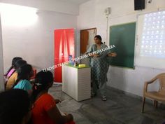 a woman standing in front of a chalk board