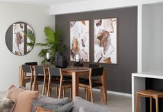 a living room with couches, tables and chairs next to each other in front of two mirrors on the wall