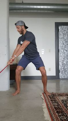 a man with a baseball cap and blue shorts is swinging a bat at a ball